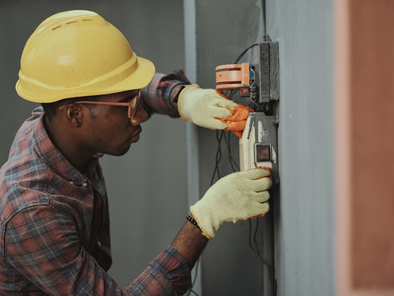 Electrician in a hard hat wiring a socket